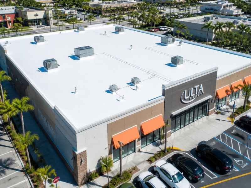 Aerial view of a completed white TPO roof on a retail building